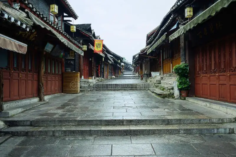 wet-stone-street-slope-old-houses-cloudy-morning-wet-stone-paved-street-slope-ancient-tile-roofed-129807532